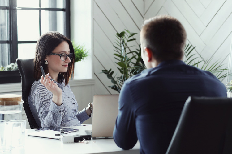 female interviewer interviewing  a male candiate in a offfice setting